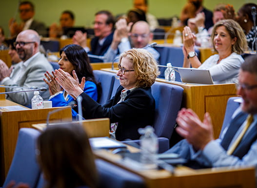 Council members applaud at a hustings meeting.