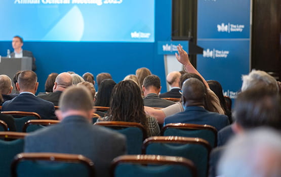 A solicitor raises their hand to speak at our annual general meeting.