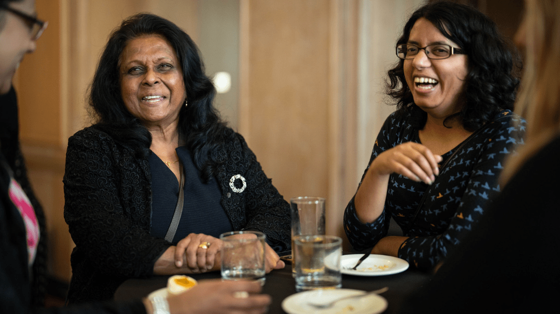 Two ethnic minority female Council members sitting down and smiling.