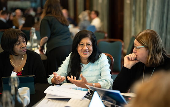 Council members smile and talk at a strategic planning event in Chancery Lane, London.