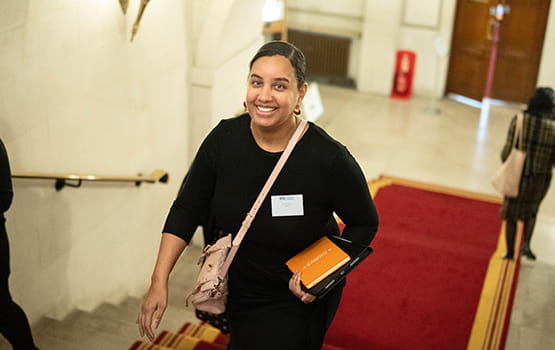 A smiling Council member walks up stairs to the Common Room of the Law Society in London.