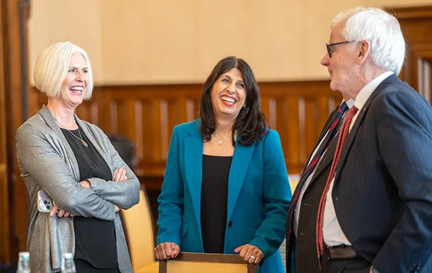 Law Society past presidents stand together, laughing and talking.