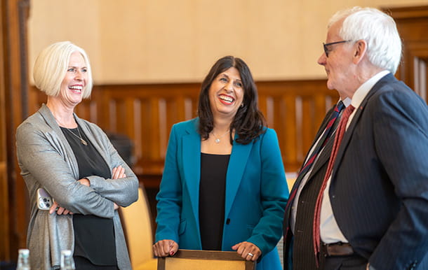Law Society past presidents stand together, laughing and talking.