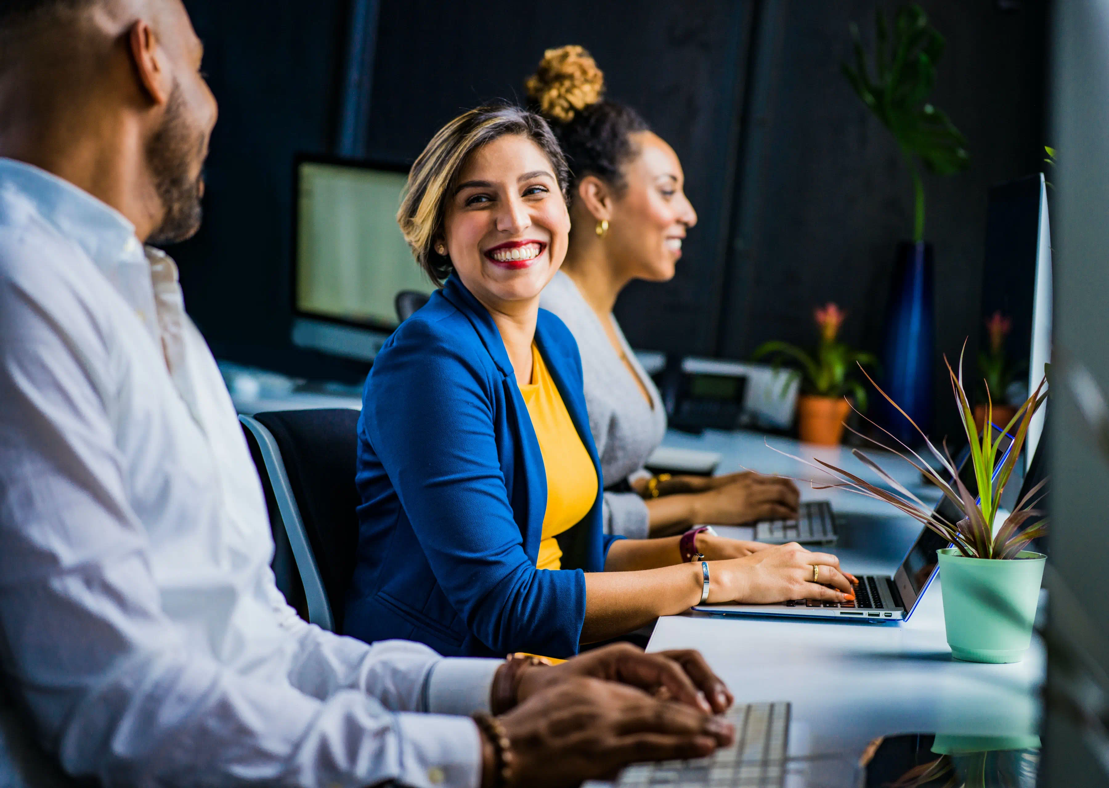 happy-employees-wellbeing-asian-woman-at-work-in-front-of-computer-beside-man