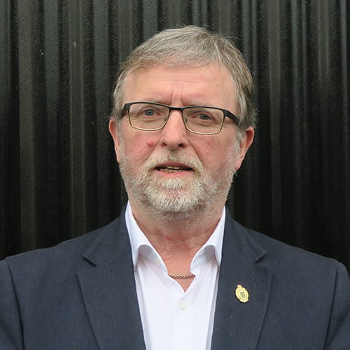 Anthony Earl wears a dark grey suit and white shirt.