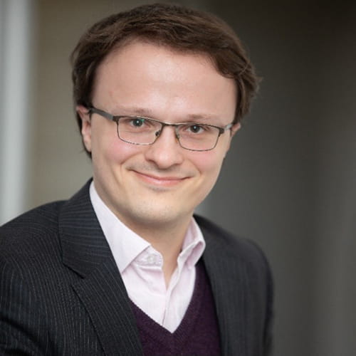 Martin Whitehorn smiles, wearing a dark suit and glasses.