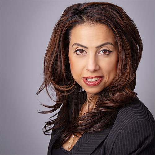 Nehal Vasani smiles, wearing a dark suit