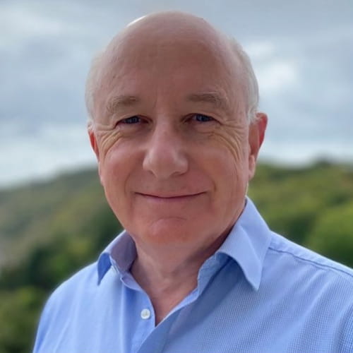 Peter Watson Lee smiles, wearing a light blue shirt.