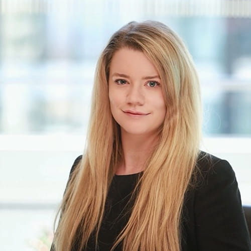 Rebecca Swinton-Bland smiles, wearing a dark suit.