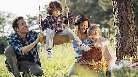 Family pushing child on a swing