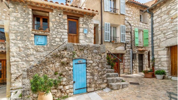 A Mediterranean courtyard with stone buildings.