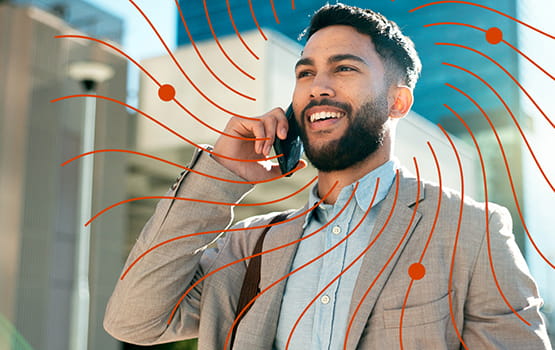 A smiling man holds a mobile phone.