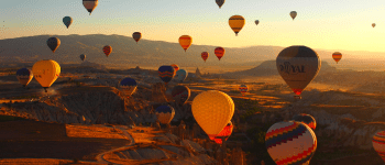 Hot air balloons in the sky above a mountain landscape