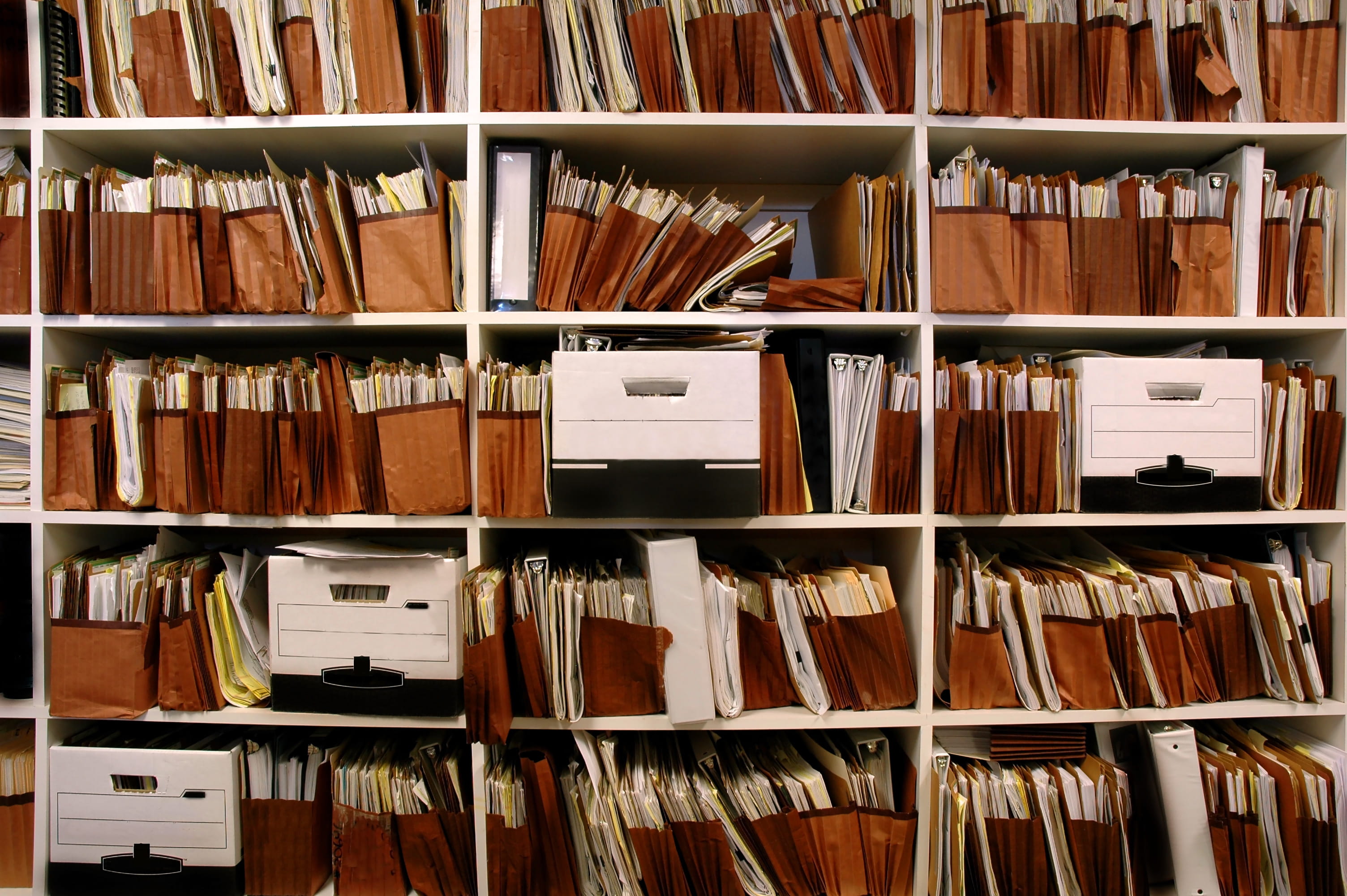 Files and boxes of documents on shelves.