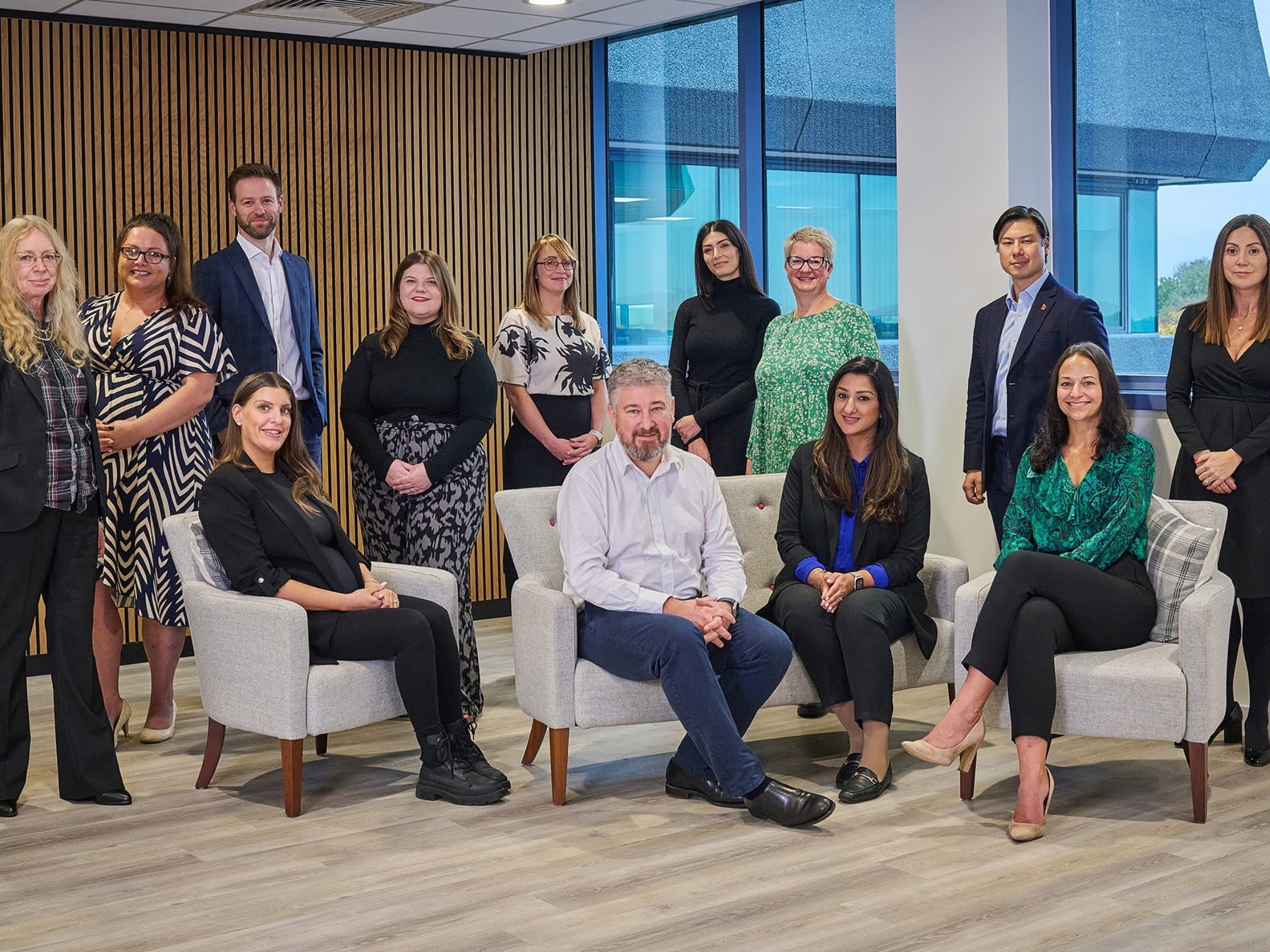 A group of people standing and sitting in an office space.