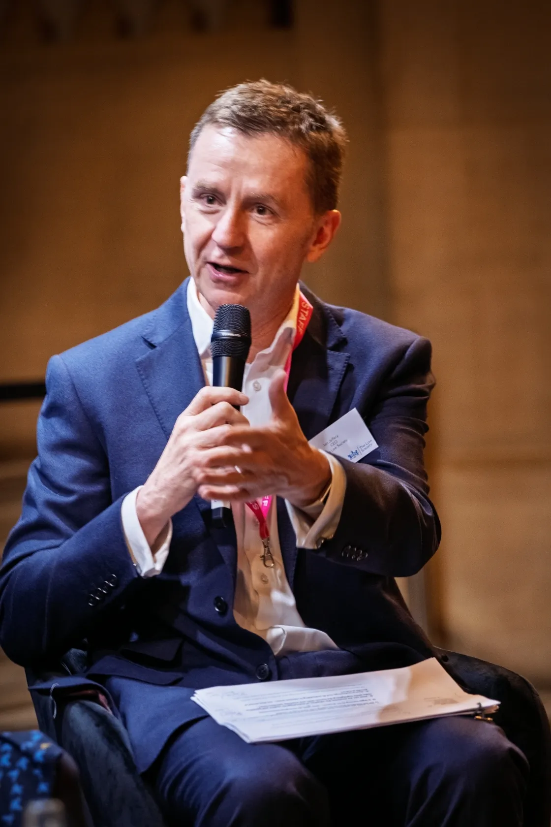 Ian Jeffery speaking and holding a microphone.