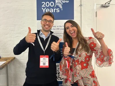 Sophie Jackson and Michael Kennedy at the Legal Geek conference smiling at the camera with their thumbs up.