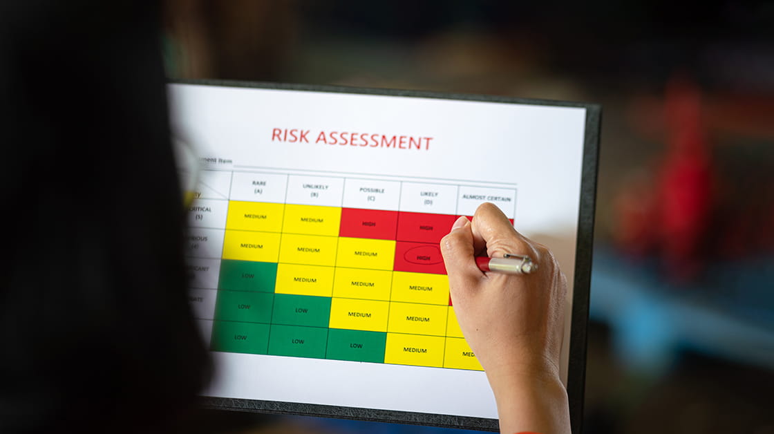 A person carries out a risk assessment, circling a likely and serious risk with a pen.