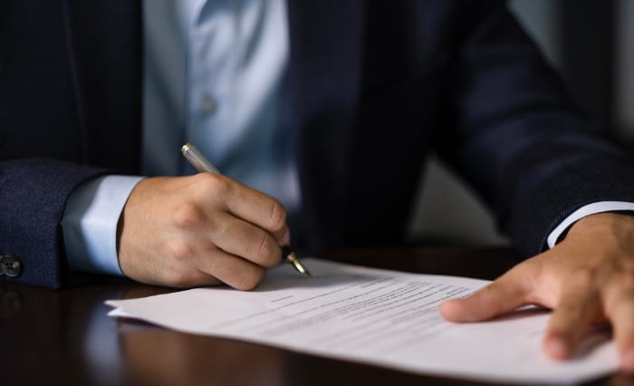 A person signs an official document.