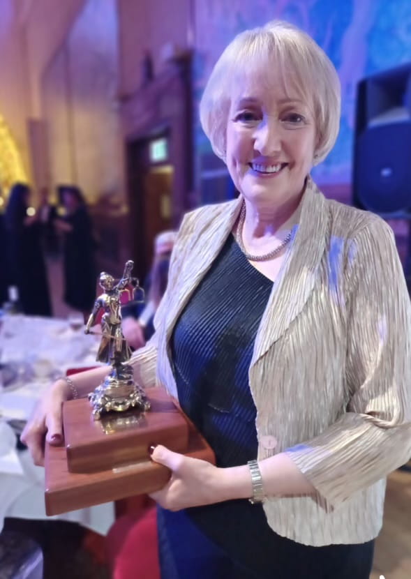 Carolyn Kirby holding an award.