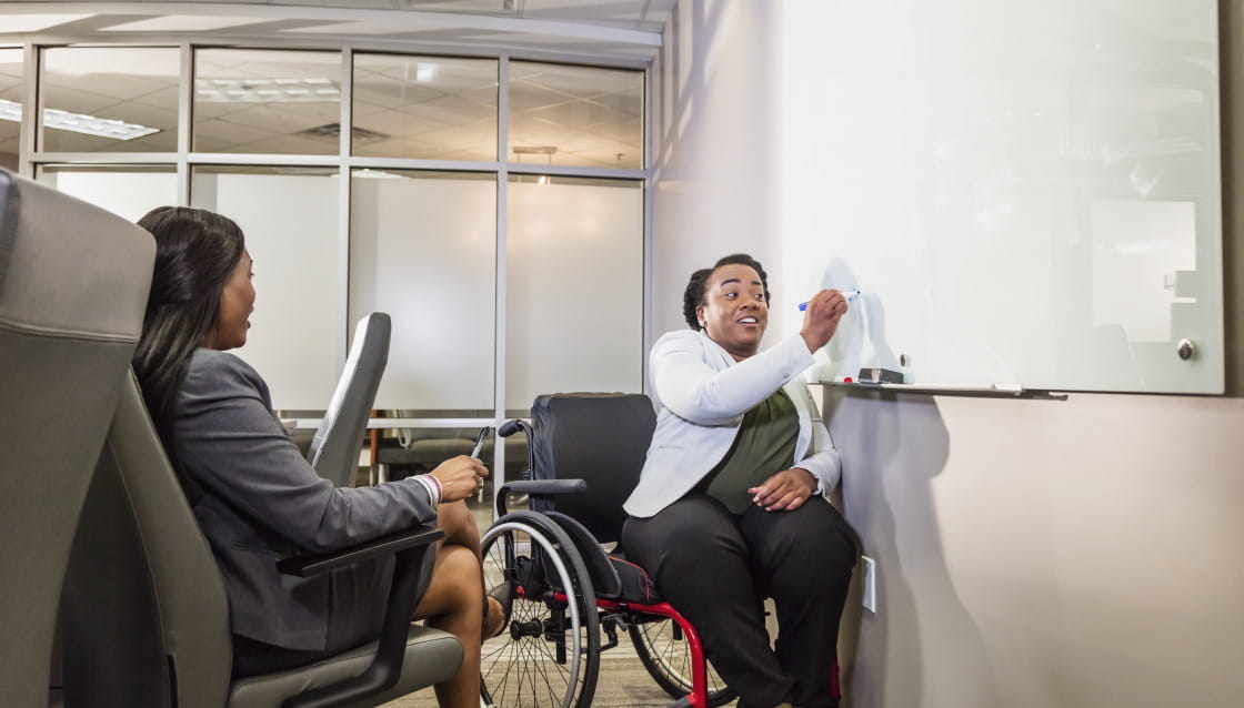 Disabled business person writing on board