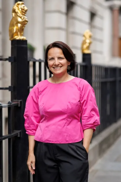  Individual in a bright pink top standing outside of the 113 Chancery Lane