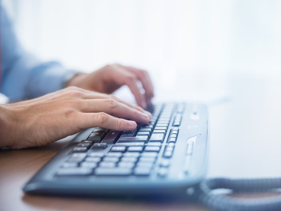 Hands typing on a keyboard.