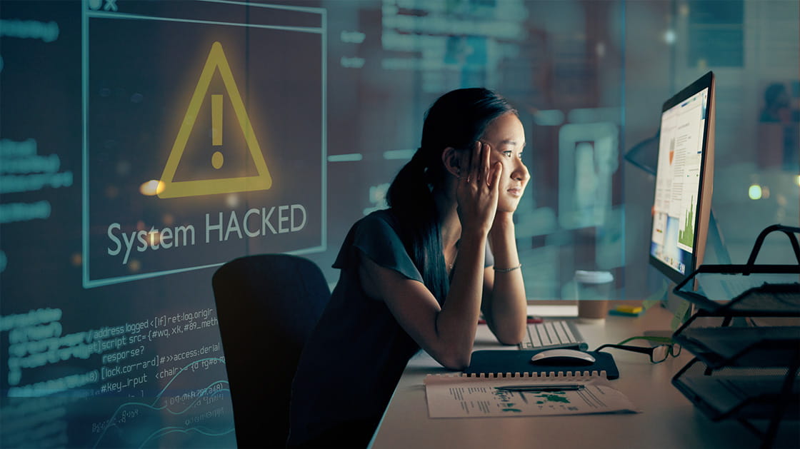 A woman looks at computer screen with a concerned expression on her face.