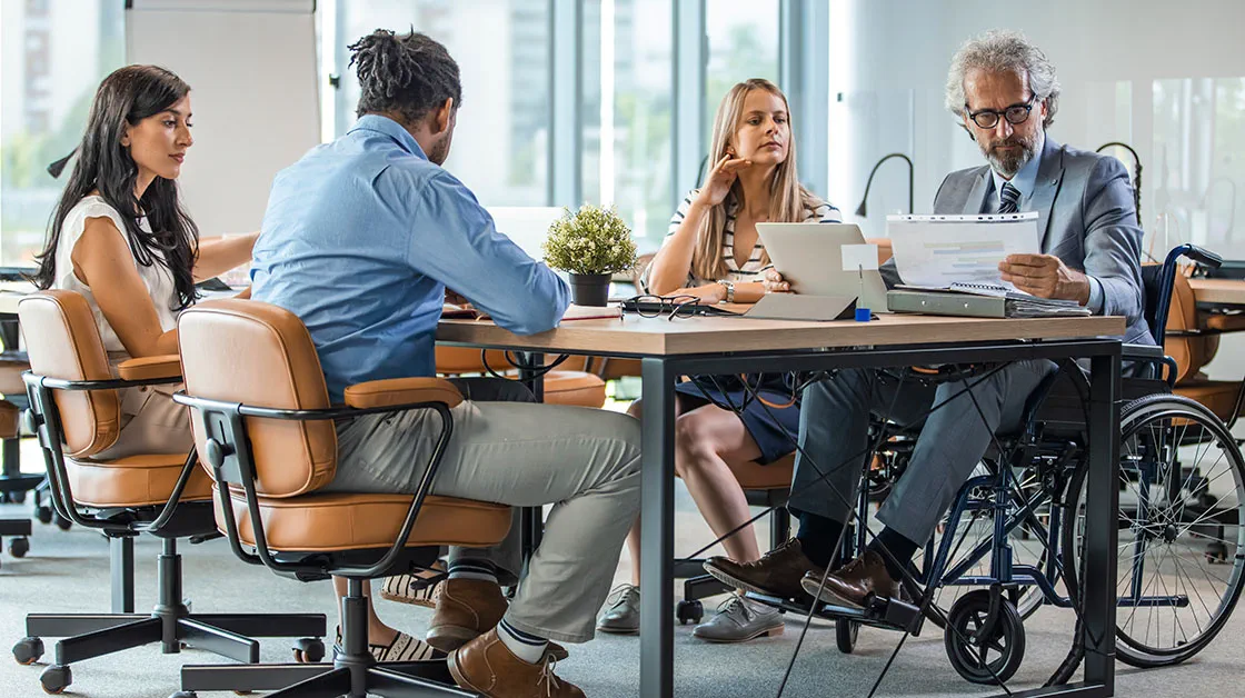 A group of diverse colleagues around a desk.