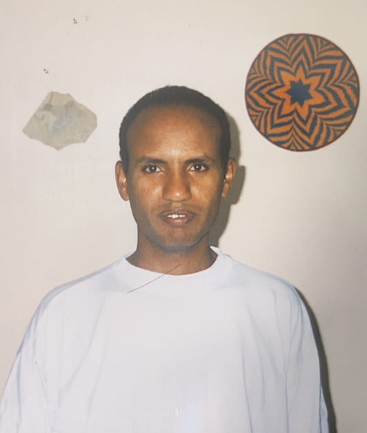 Solicitor Abraham Ghebre-Ghiorghis as a young man wearing a white t-shirt
