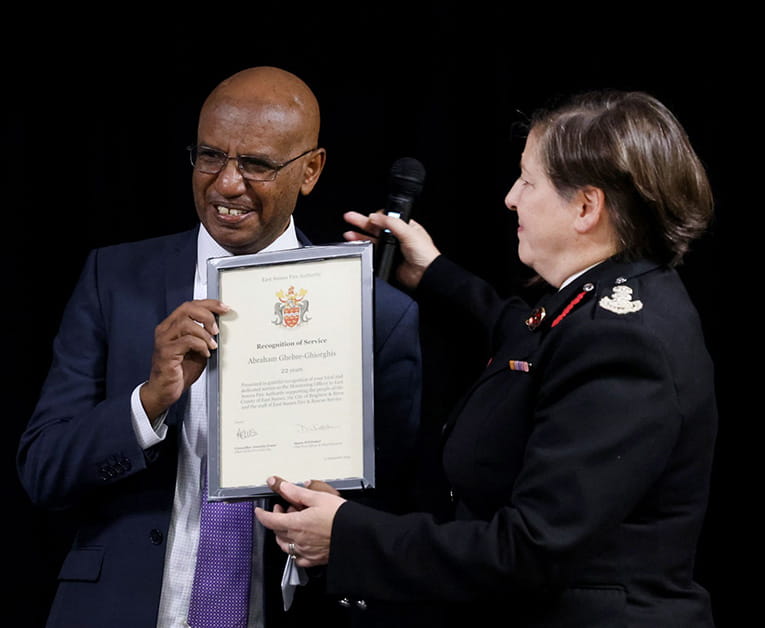 Solicitor Abraham Ghebre-Ghiorghis receives a certificate for 22 years of service from Dawn Whittaker