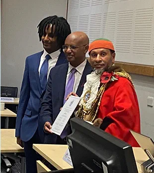 Solicitor Abraham Ghebre-Ghiorghis poses for a photo with his son and Mayor Mohammed Asaduzzaman