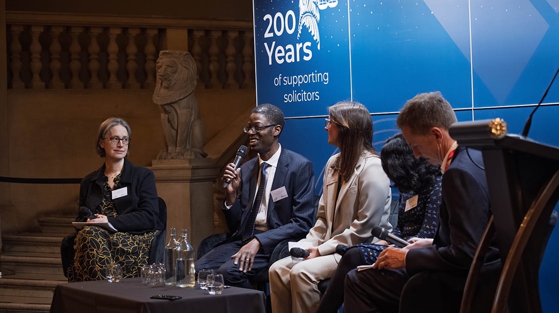 A panel of legal professionals on stage at a Law Society bicentenary event where solicitor Karl Brown is speaking