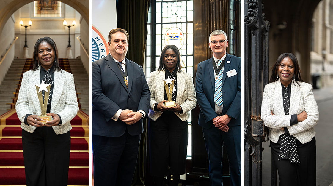 Pauline Campbell is a black woman with short brown hair, she is wearing a white jacket, black blouse and black and white stripy tie. On the left she is standing in front of some stairs holding a gold trophy, in the middle she is standing between our president and vice president, holding the trophy and on the right she is outside leaning against a gate. 
