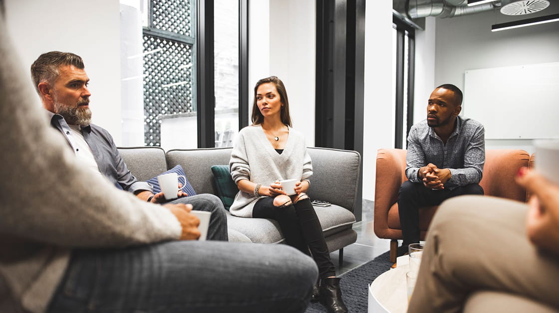 A group of people sat in a supportive meeting.