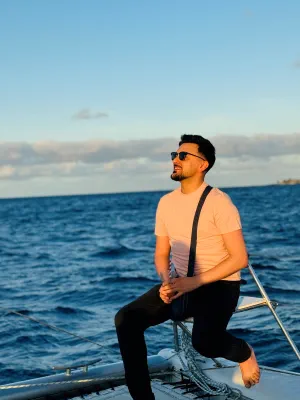 Qays sits on a boat, looking up at the sky.