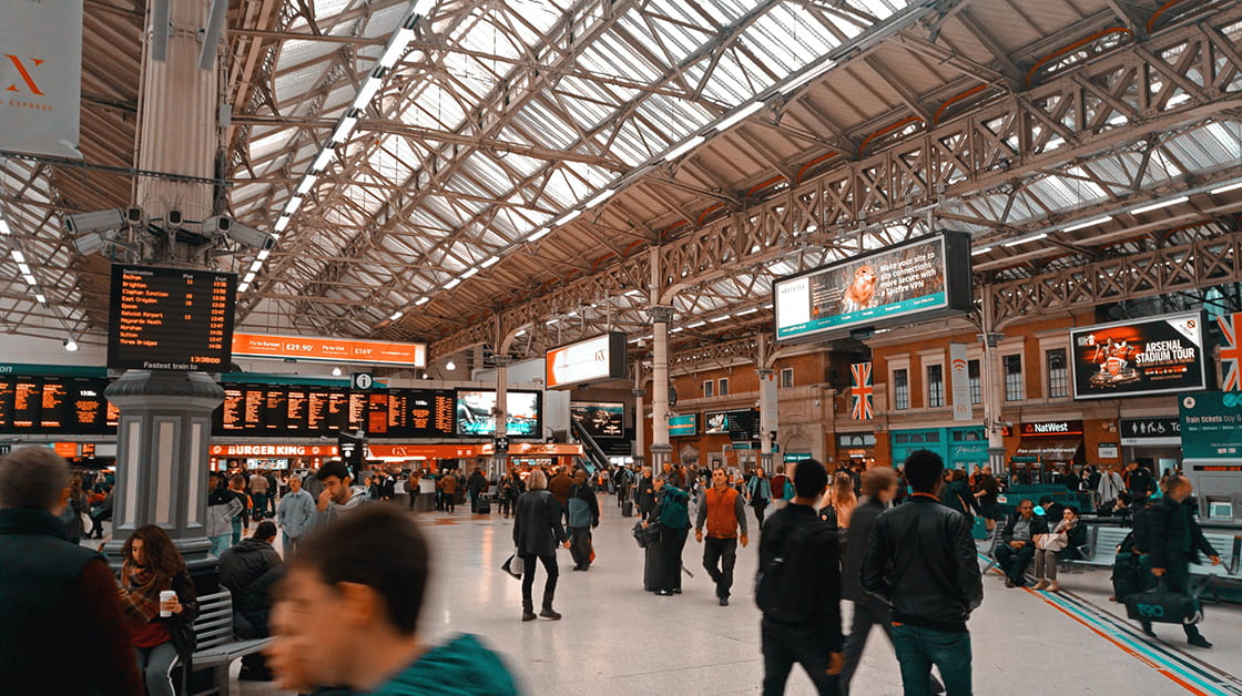 Busy concourse at Victoria train station, London - blurred people in foreground