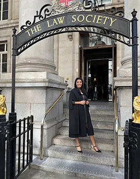 Carolina Falloon stands in front of the Law Society, wearing admission ceremony robes.