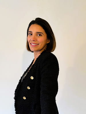 Carolina Falloon wears a suit and smiles at the camera.