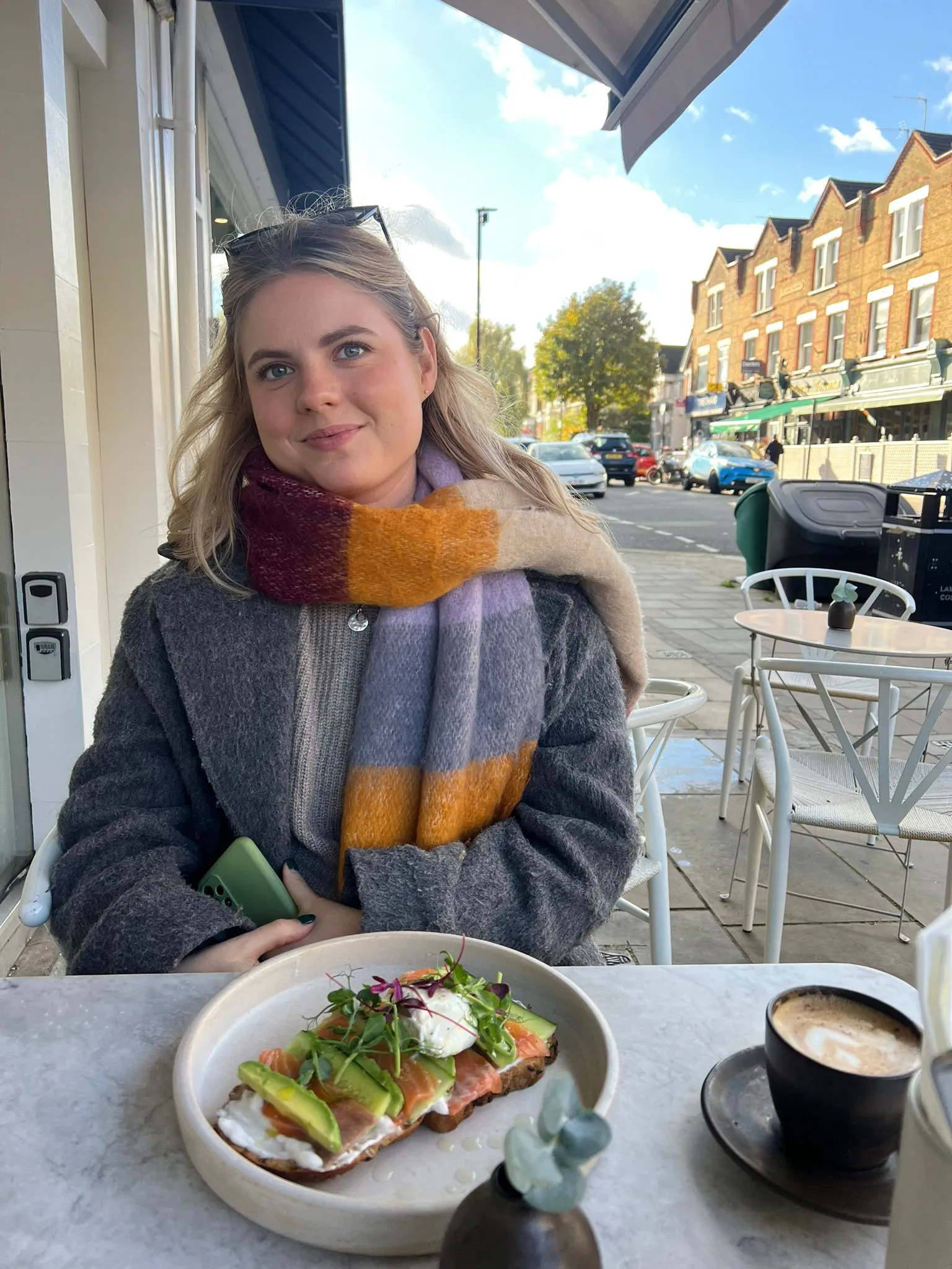 A woman sits outside a café.