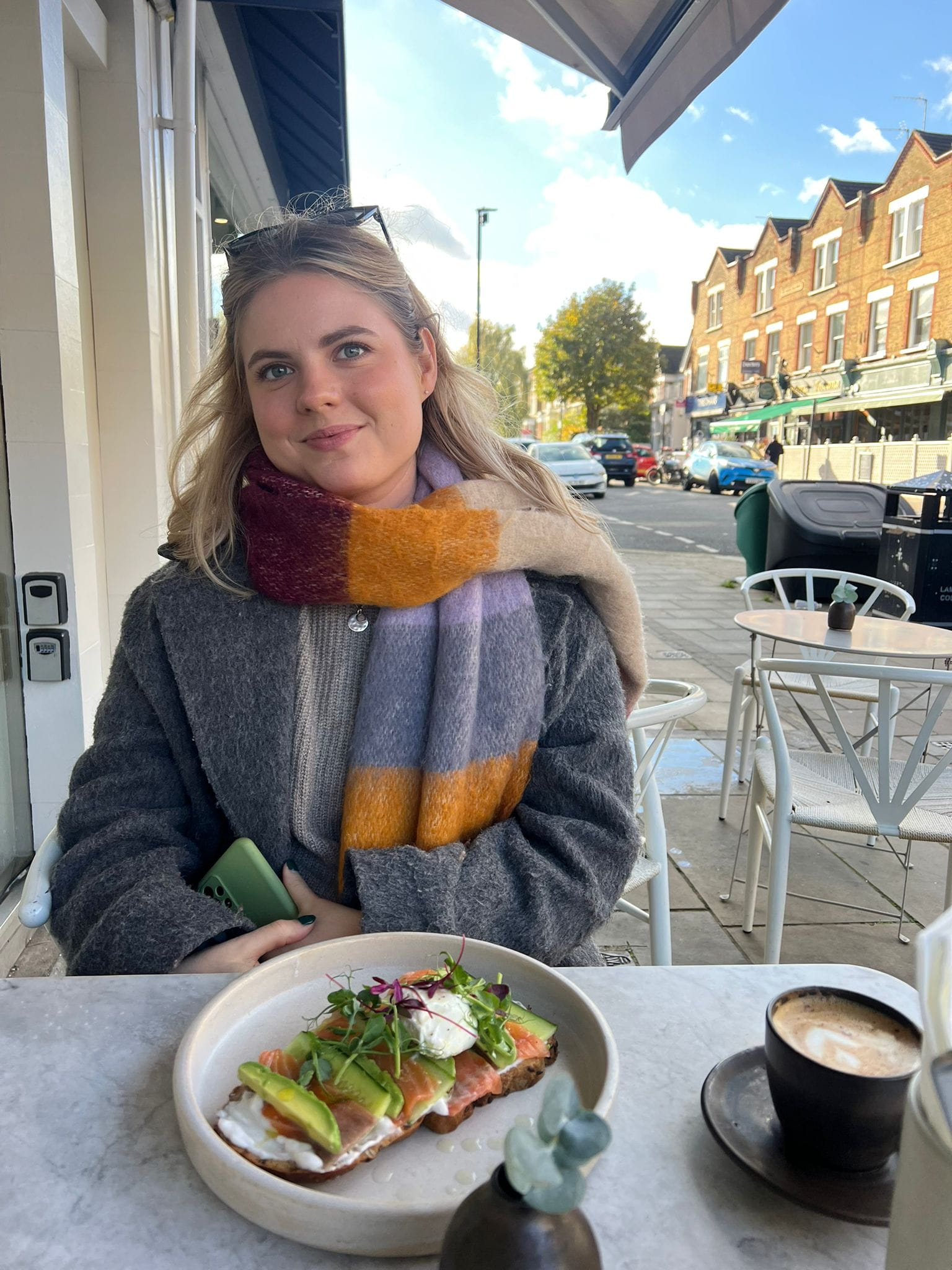 A woman sits outside a café.