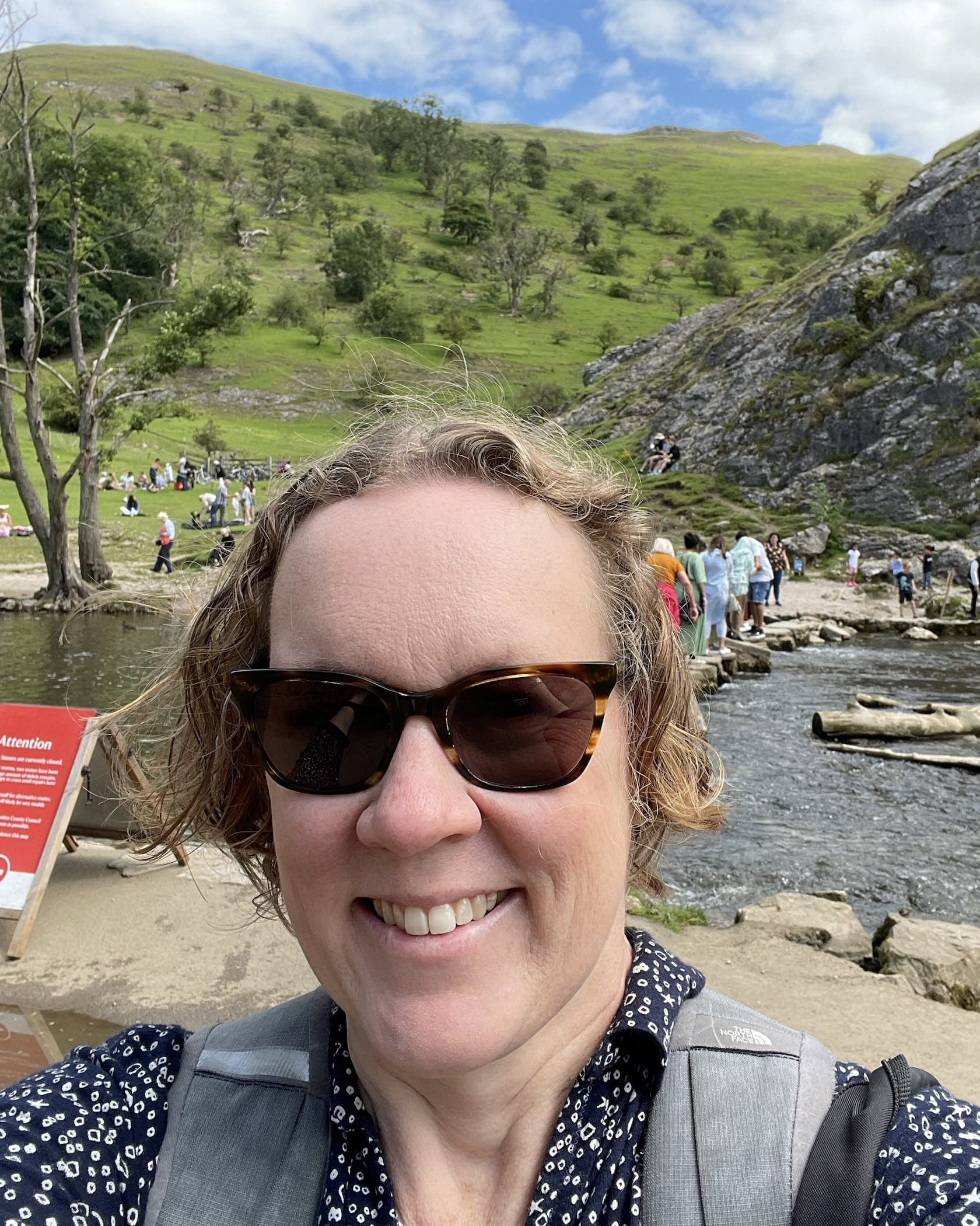 Hilary Watts smiles by a lake.