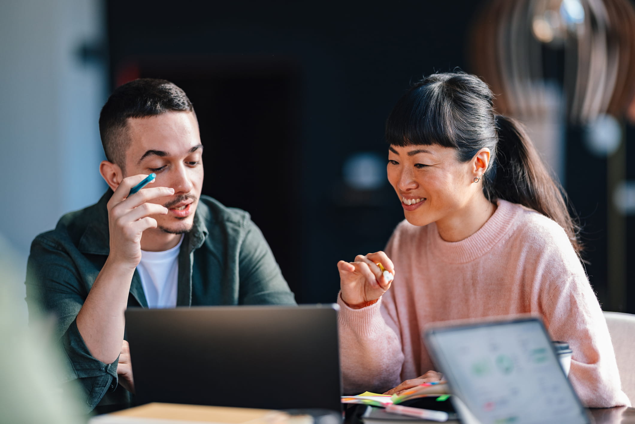 Two people having a conversation in front of a laptop.