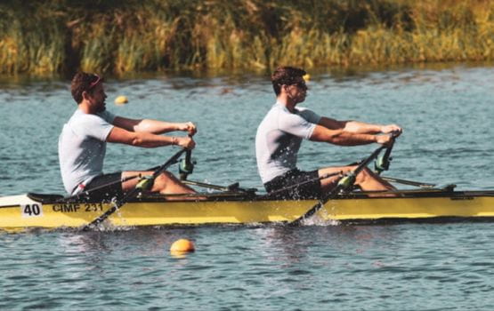 Tom Solesbury rowing with a partner on a river.