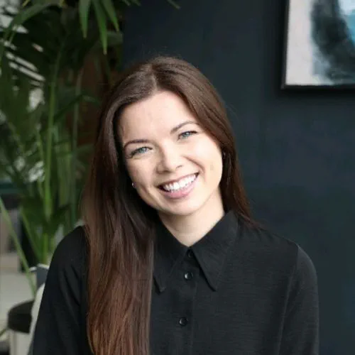 Tríona Lenihan smiling whilst wearing a black shirt. She is a white woman with long dark hair