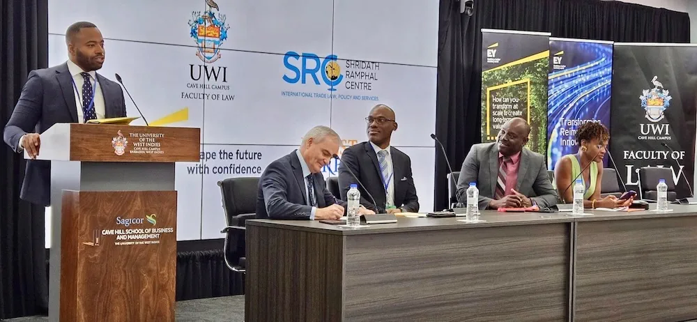 Jivaan Bennett speaks at a podium alongside a panel.