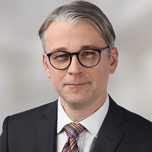 Chris Fawcett is a man with grey hair and glasses.