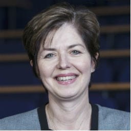 Elisabeth Russell has short brown hair and is wearing a suit jacket.