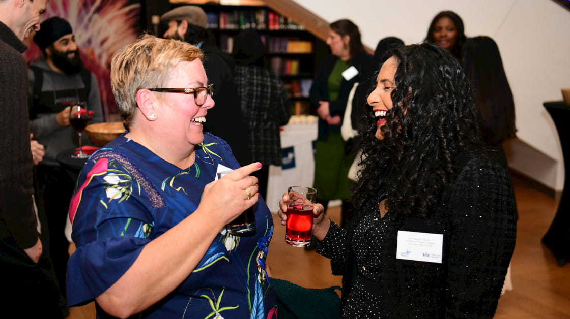 Two smiling and laughing solicitors attend our Birmingham bicentenary event.