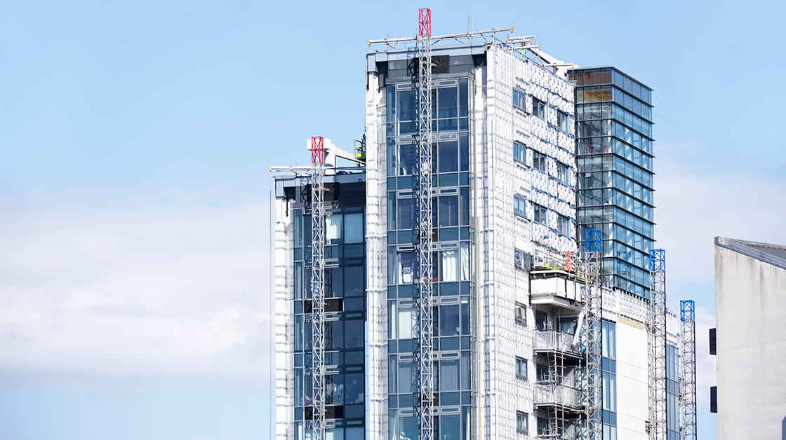 A high-rise building has its cladding replaced during fire safety remediation works.